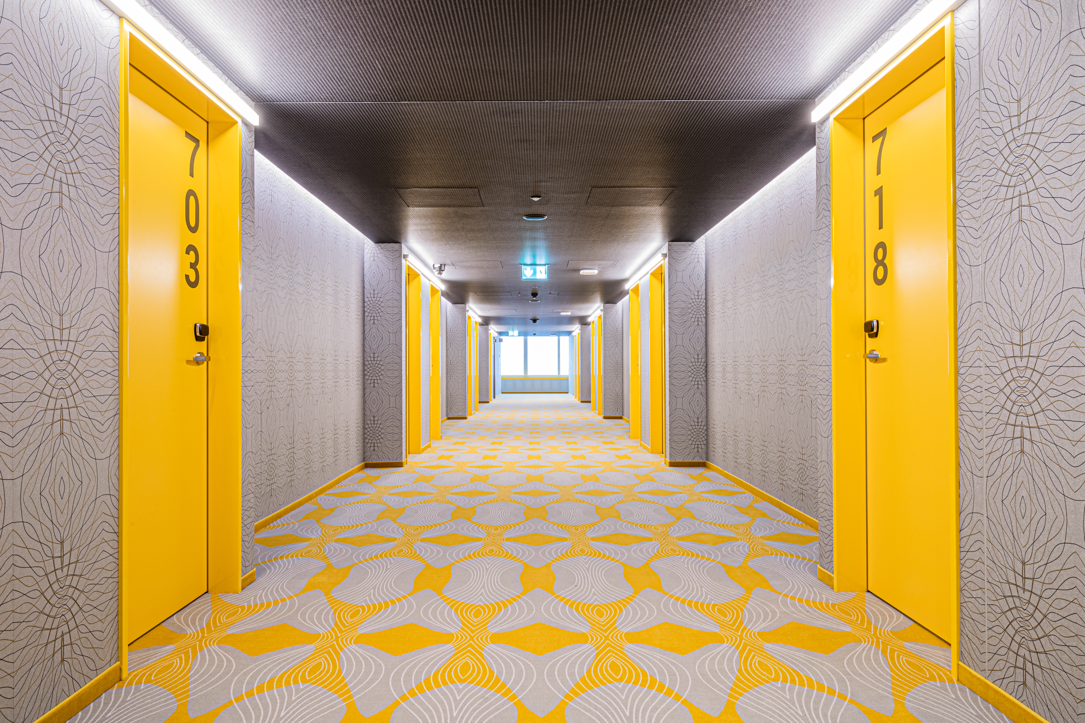 Der Flur des Hotels im gelben Design und gemustertem Boden
