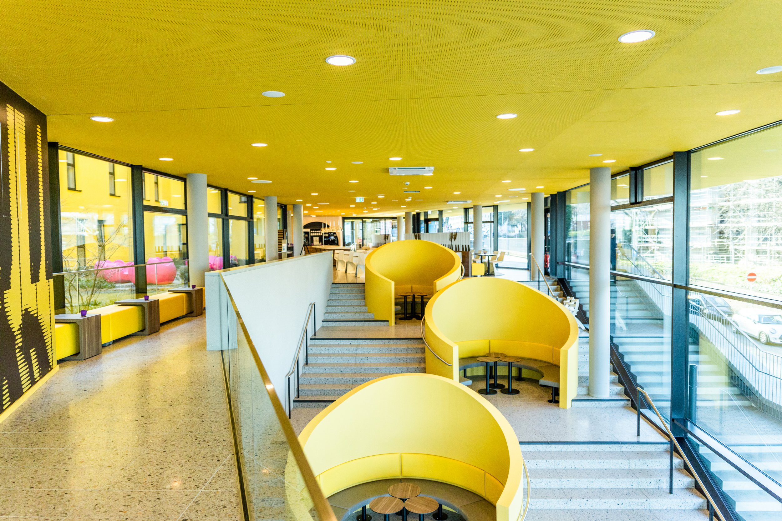Das gelbe Treppenhaus mit großen Sitznischen im prizeotel Bonn