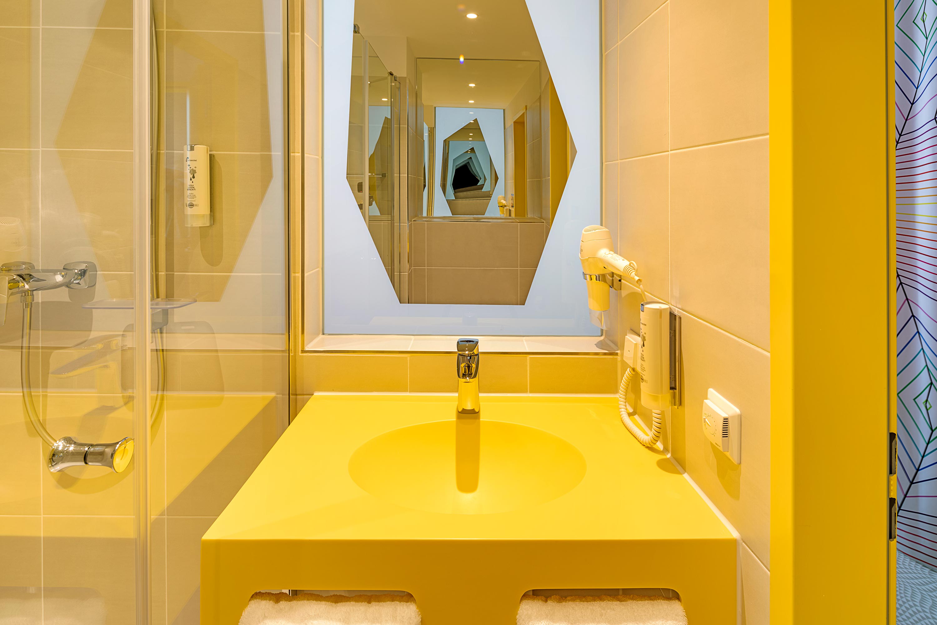 Ein gelbes, kleines Badezimmer mit Dusche