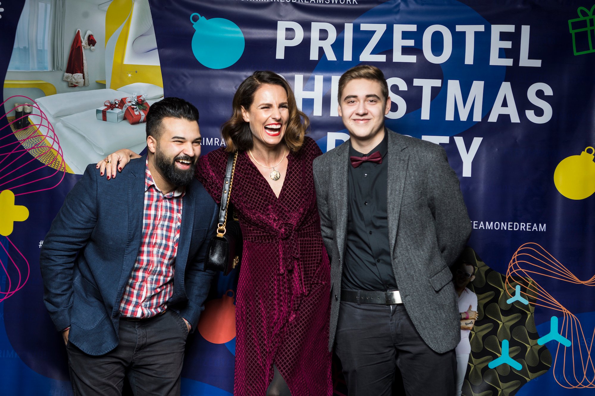 Ein Frau steht lachend mit zwei Männern vor der Kamera auf der prizeotel Weihnachtsfeier