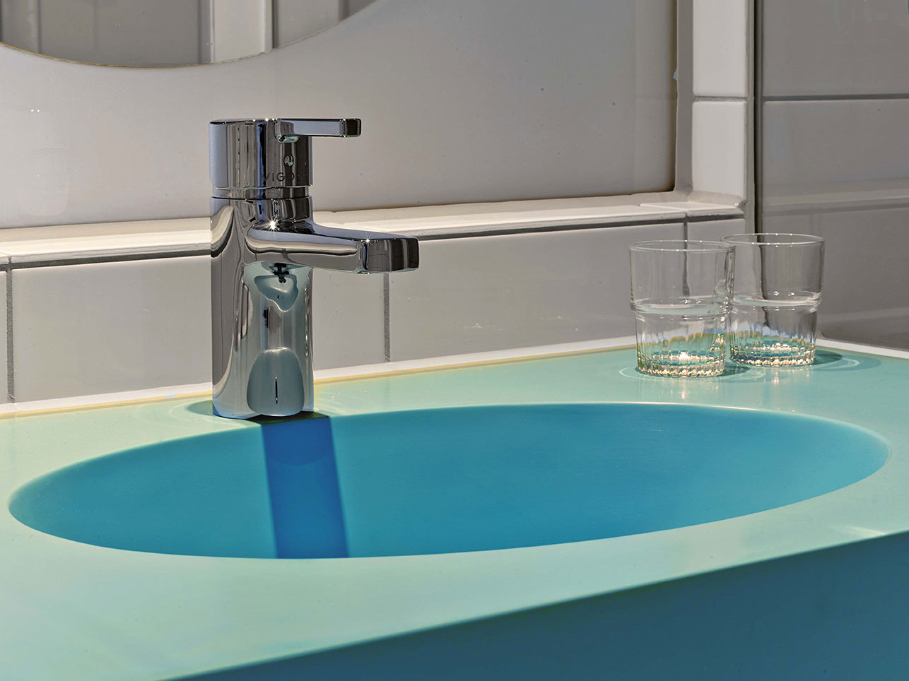 Detail eines blauen Waschbeckens mit zwei bereitgestellten Gläsern