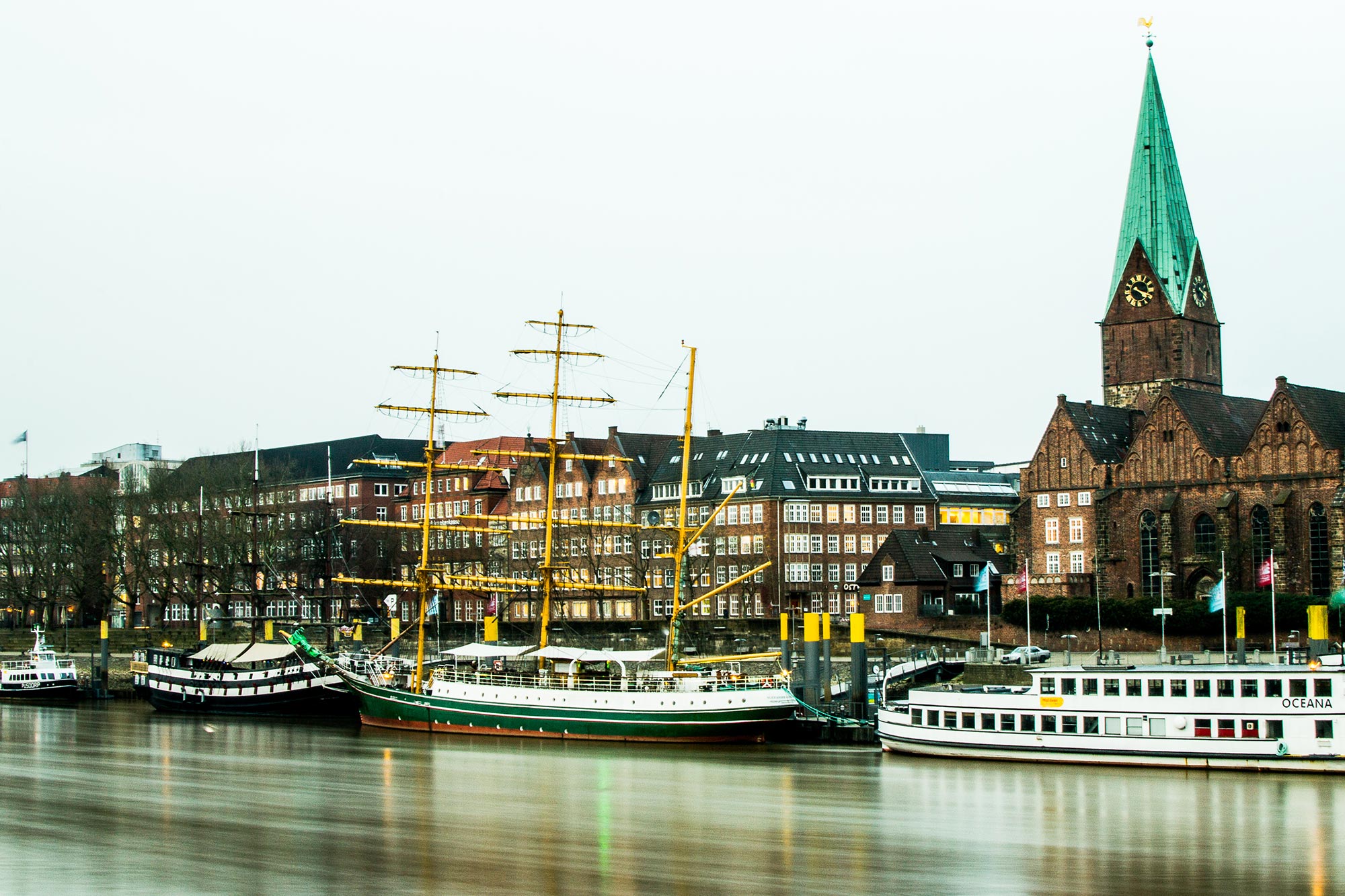 A few boats are floating over the harbour in Bremen City