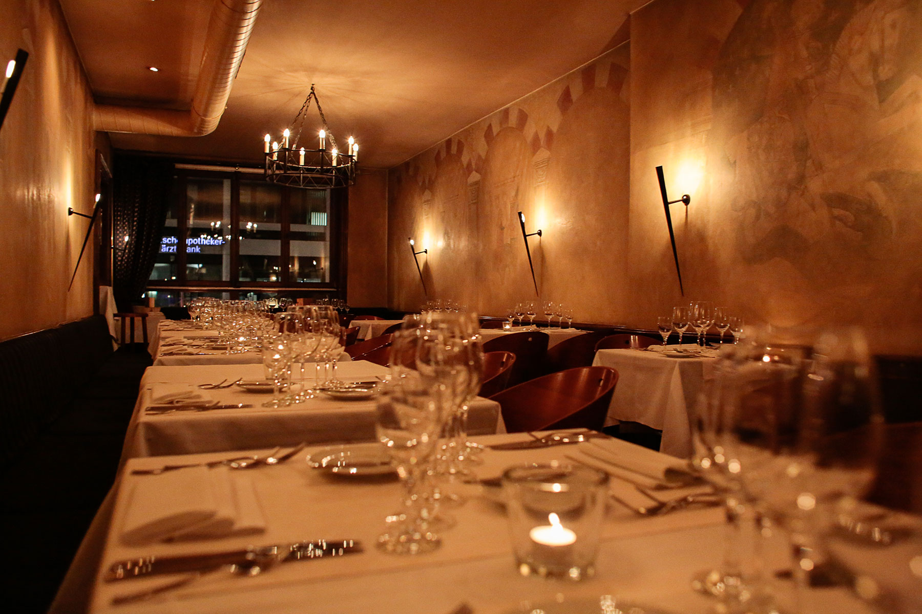Schummriges Restaurant mit gedeckten Tischen und schwachen Lichtern