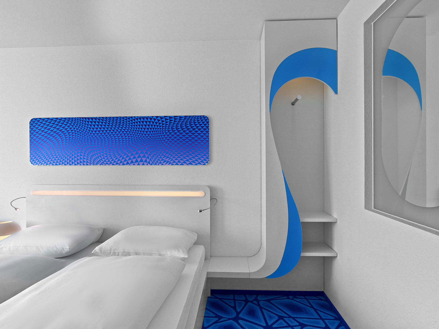 Design hotel room with blue elements, a double bed and an open wardrobe