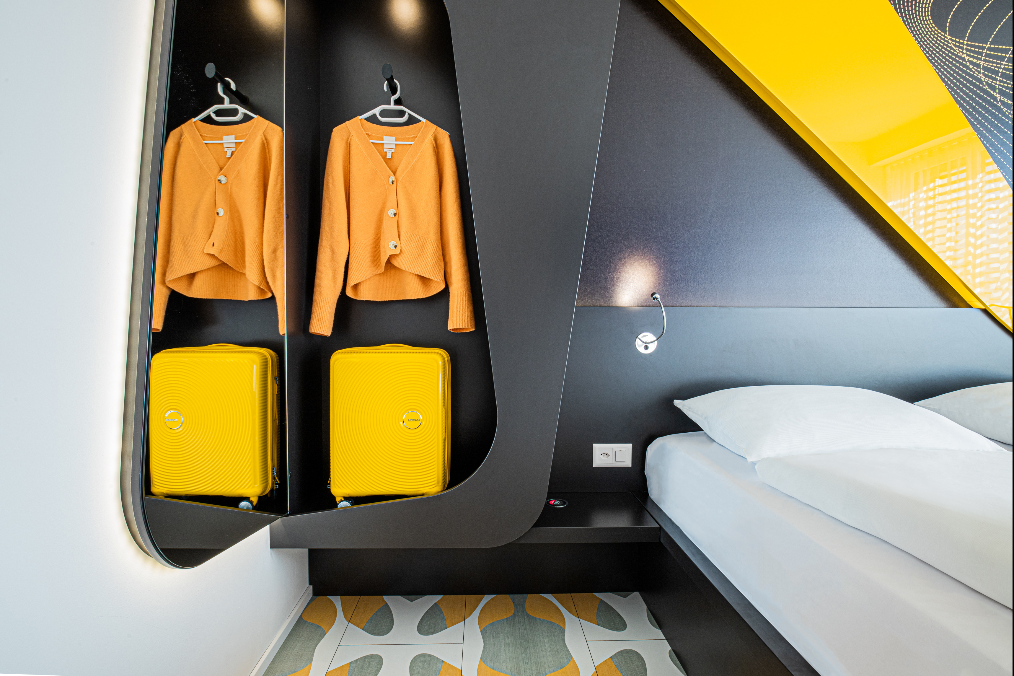 Hotelzimmer mit offenem Kleiderschrank und Kofferablage
