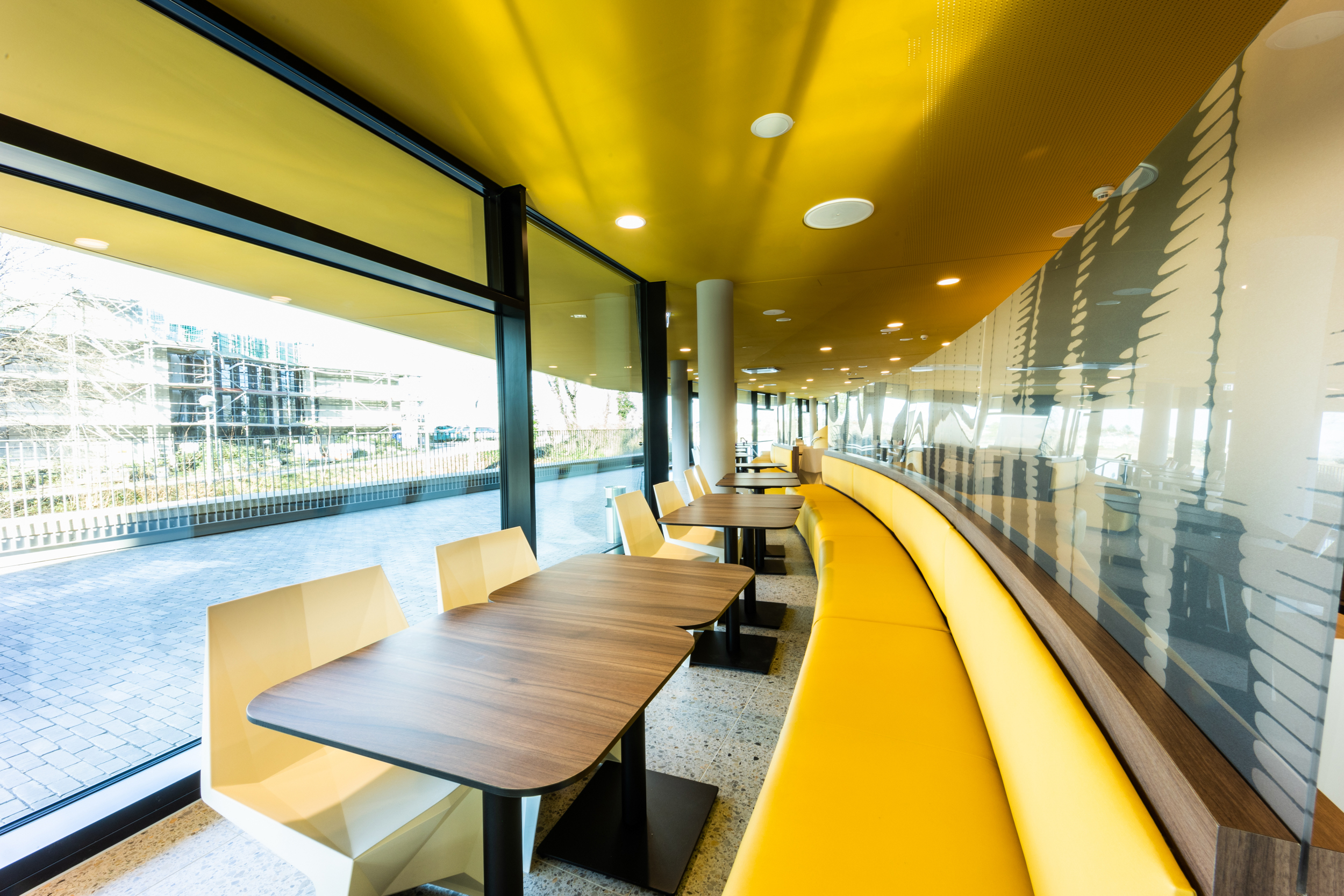 Der gelbe Frühstücksbereich des Hotels in Bonn mit Blick nach draußen
