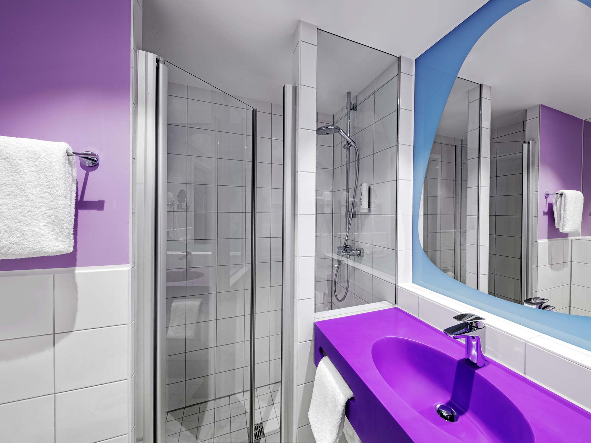 Ein hippes Badezimmer im prizeotel Erfurt mit lilanem Waschbecken