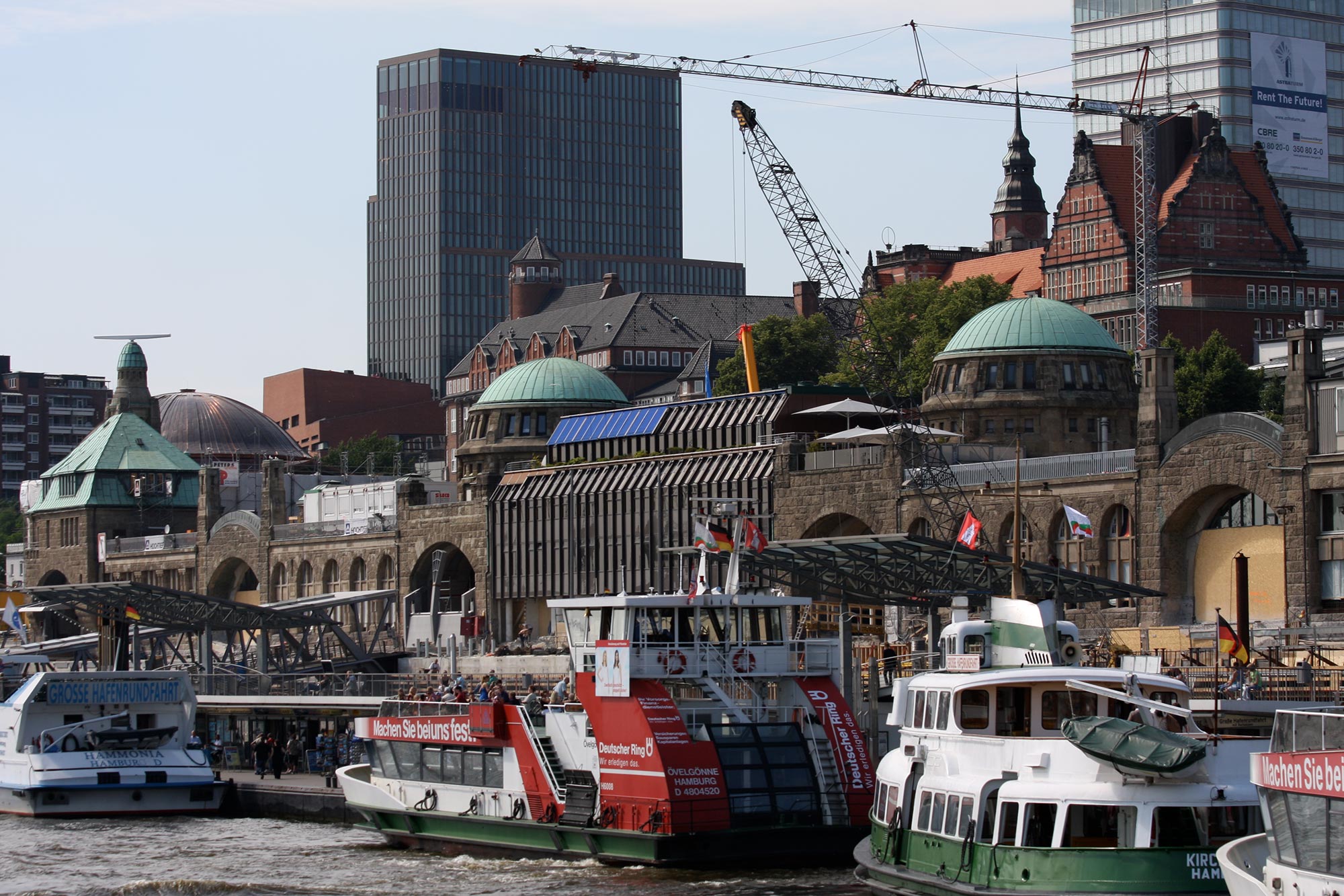 Anlegende Boote und Wassertransporte am Hamburger Hafen mit alten Gebäuden im Hintergrund
