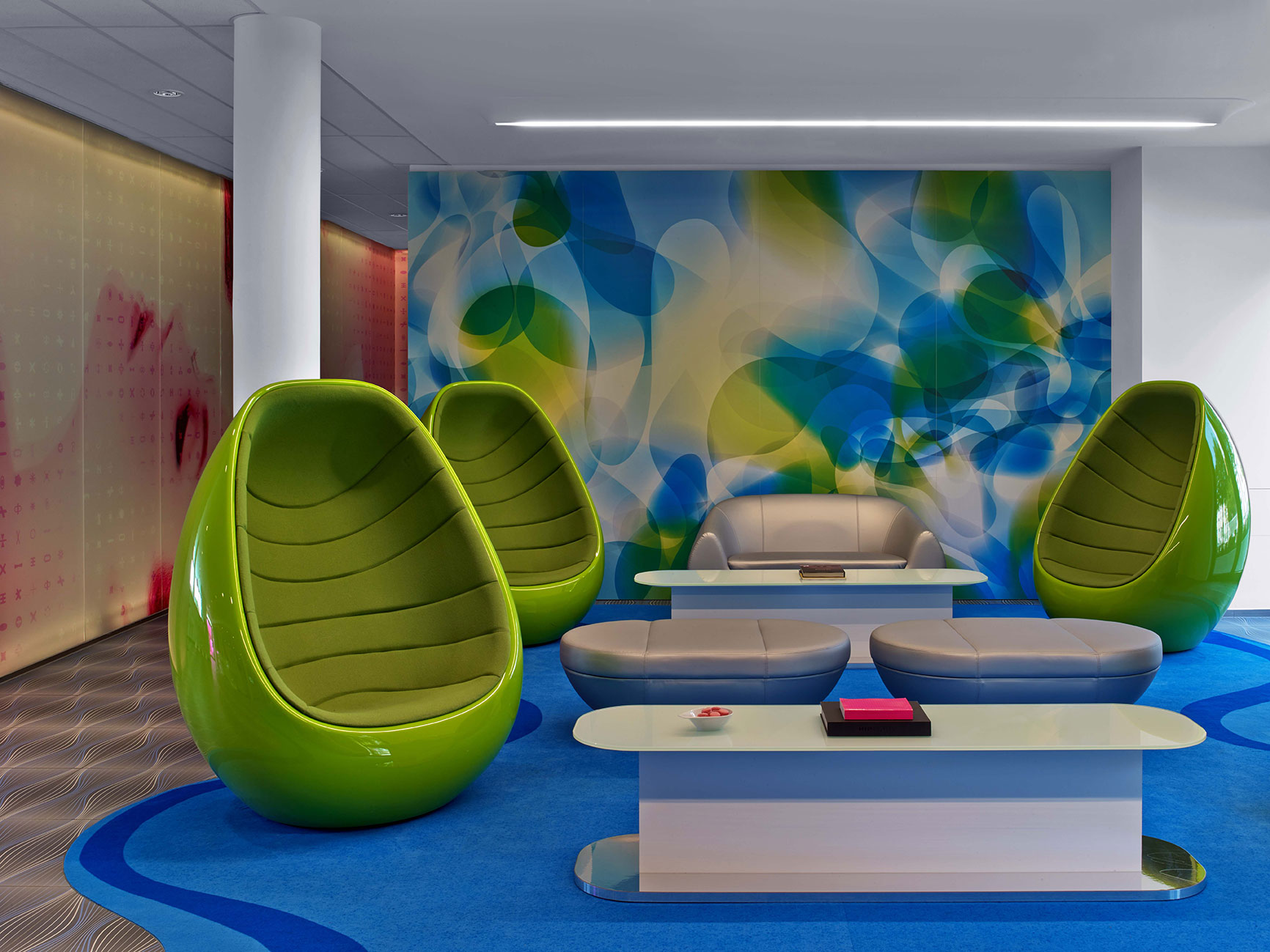 Die Lobby-Lounge im prizeotel Hamburg-City mit grünen Egg Chairs und weiteren modernen Möbeln