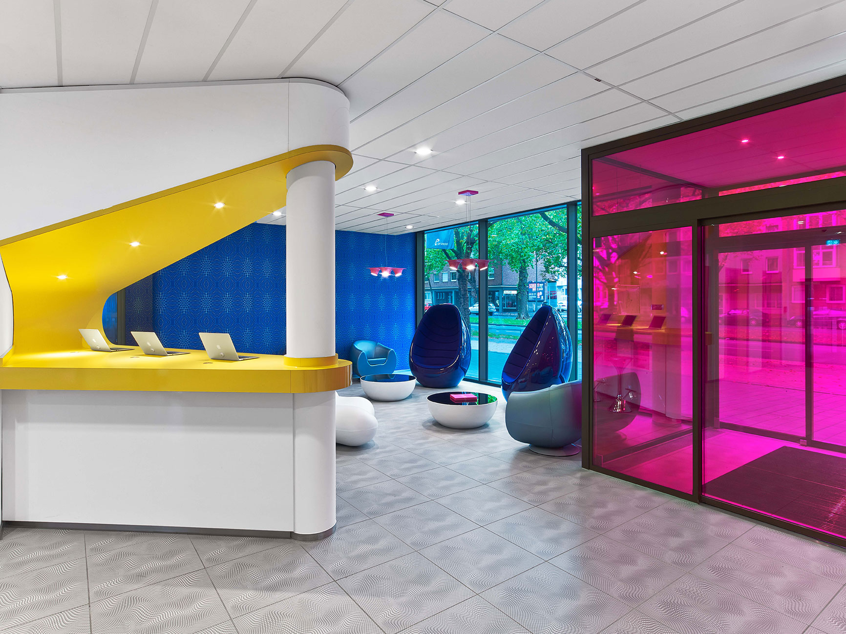 Reception at prizeotel Hanover-City with a small lounge and a colourful entrance door