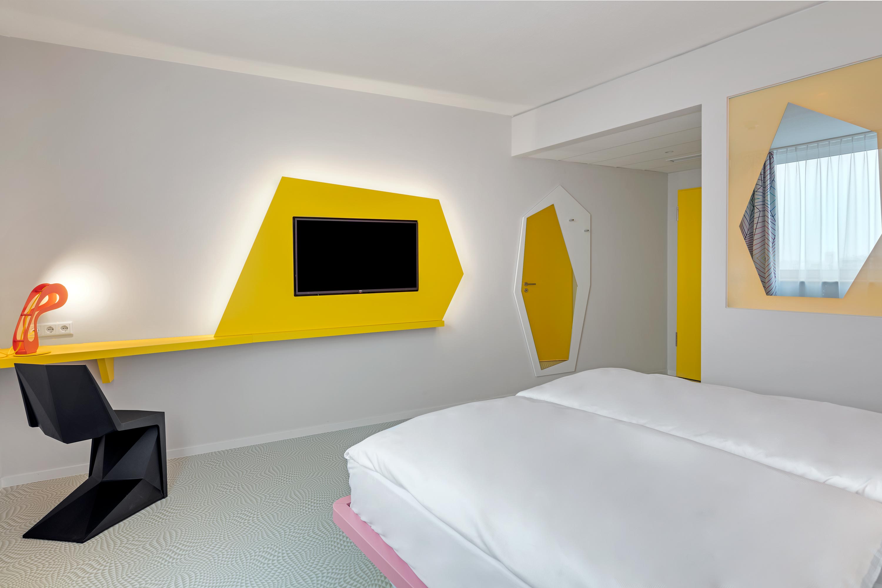 Blick vom Bett aus auf einen Fernseher auf gelben Hintergrund