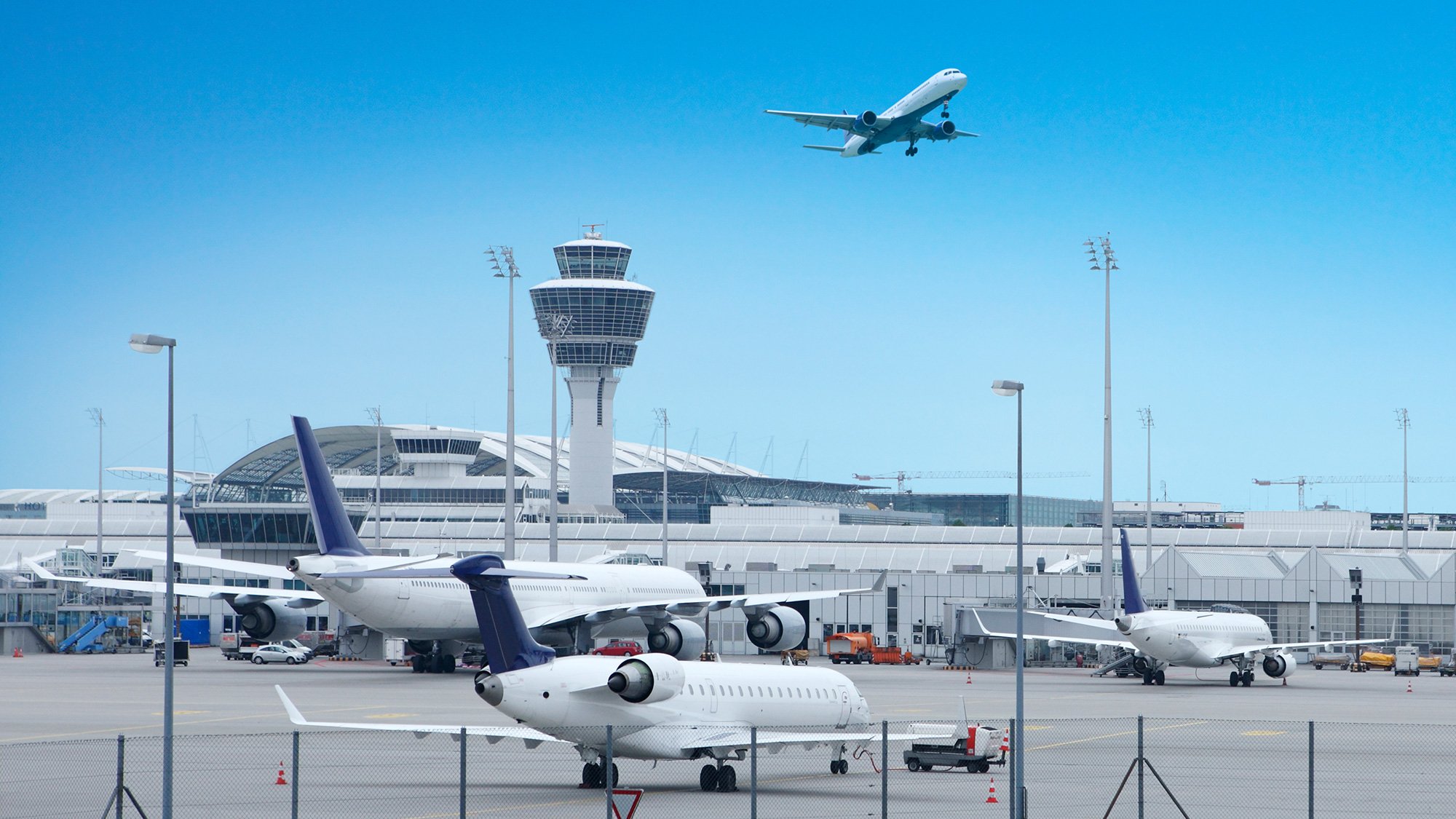 Münchner Flughafen mit abfliegenden Flugzeugen und dem Tower im Zentrum