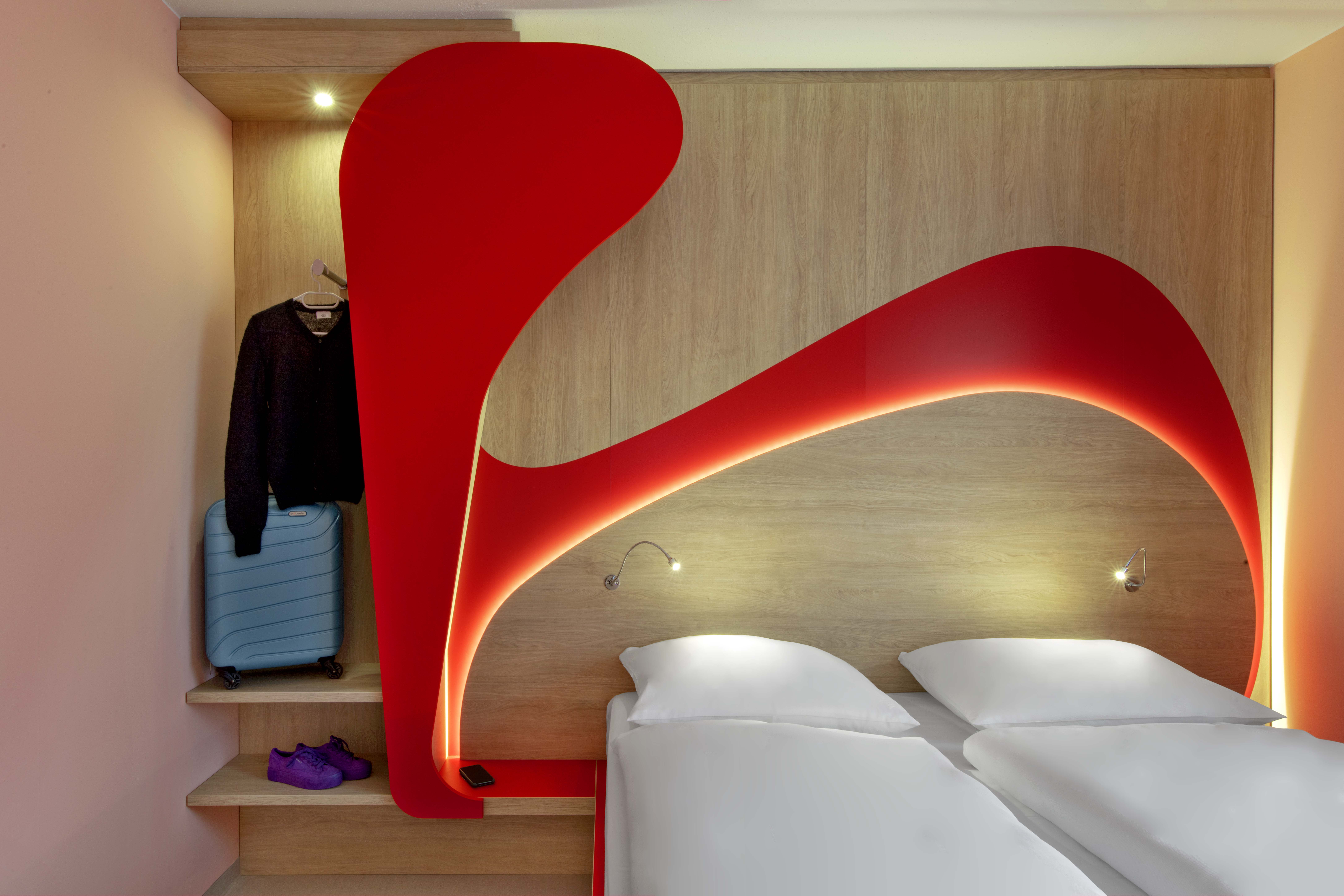 Designzimmer des Hotels am Flughafen Münchne mit Doppelbett und offenem Kleiderschrank
