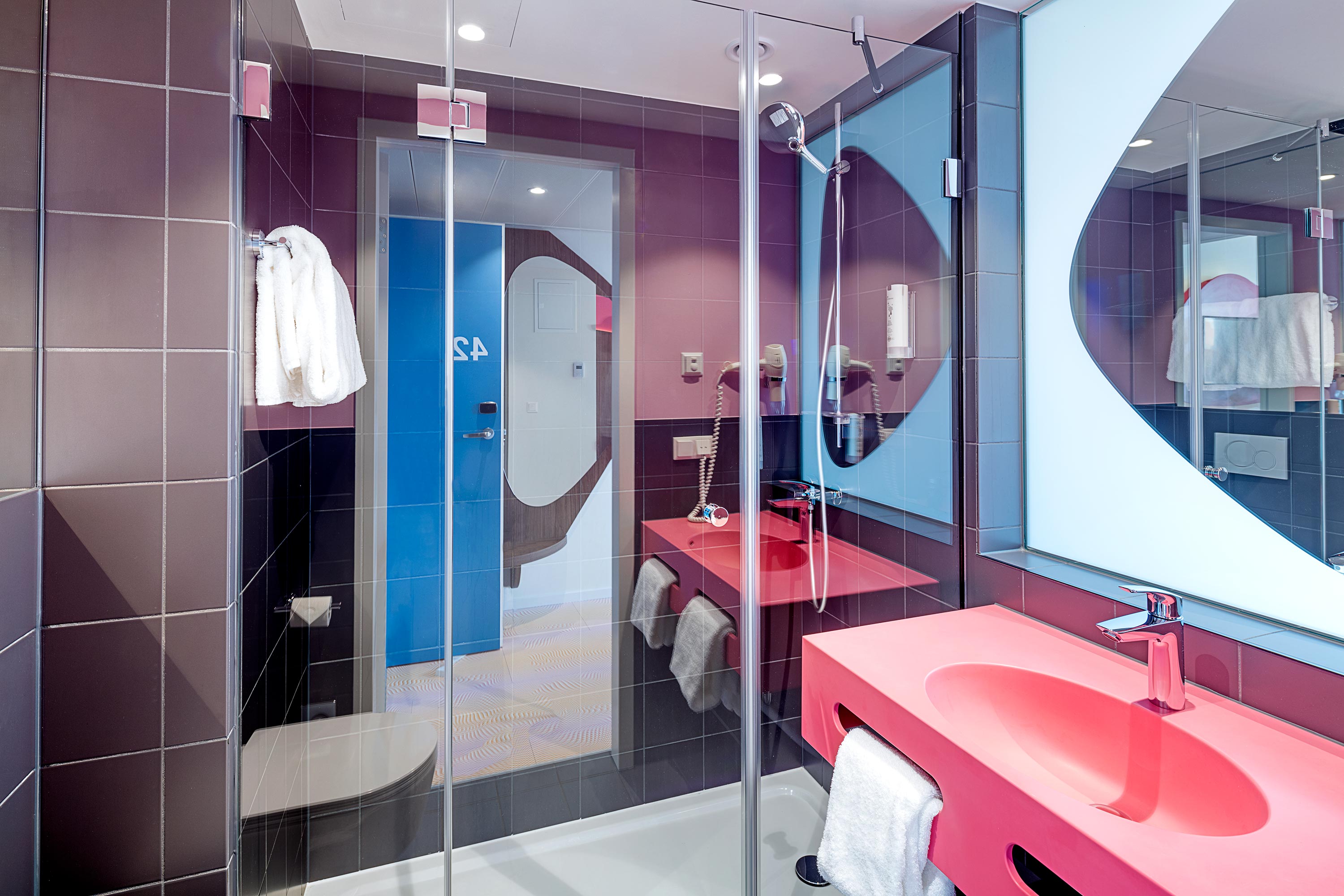 Das schwarz-pinke Badezimmer des Hotelzimmers im prizeotel Wien