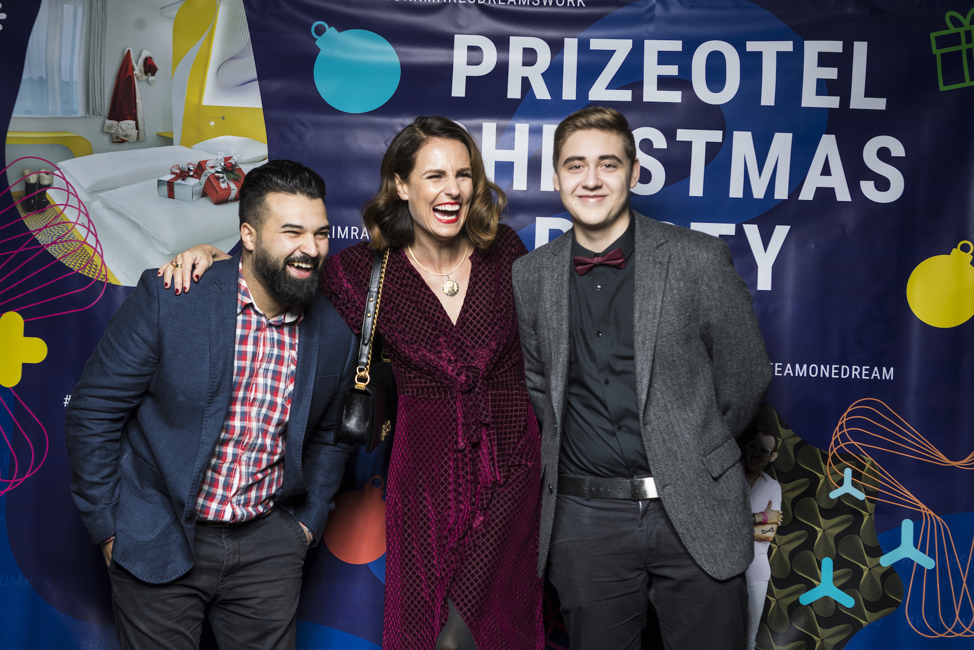 Ein Frau steht lachend mit zwei Männern vor der Kamera auf der prizeotel Weihnachtsfeier